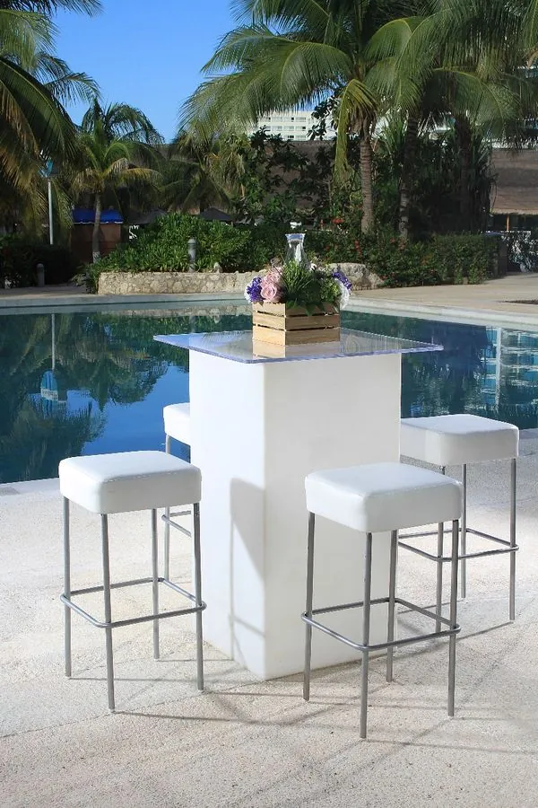 Mesa periquera blanca con bancos junto a la alberca